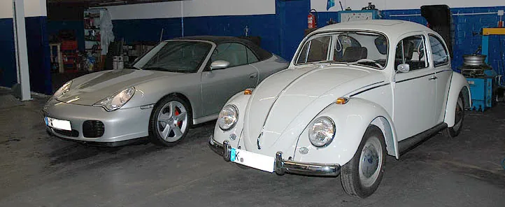 Zwei Fahrzeuge in der Werkstatthalle von W & S: ein Porsche 911 und ein VW Käfer